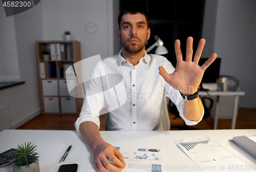 Image of businessman using gestures at night office
