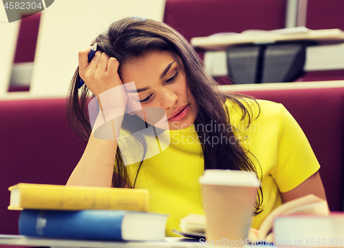 Image of student girl with books and coffee on lecture