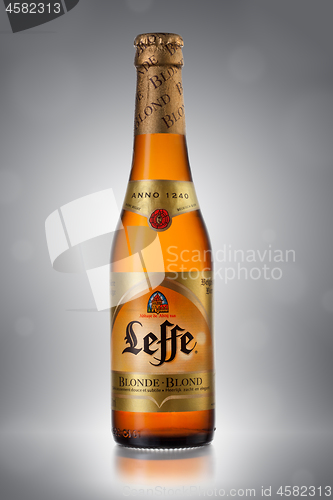 Image of UKRAINE, KYIV - APRIL 6, 2013. Bottle of Leffe Blond beer on a gray background.