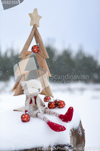 Image of Simple Christmas tree in snow with baubles and christmas decorat