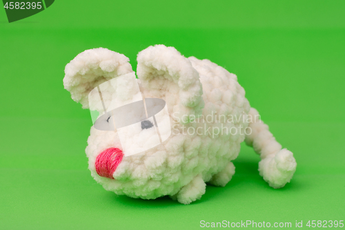 Image of White knitted mouse, made with its own hands, on a green background