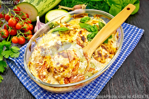 Image of Zucchini baked with tomatoes in glass pan on board