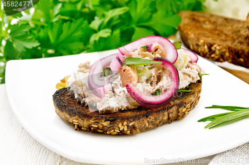 Image of Bruschetta with fish and curd in plate on board