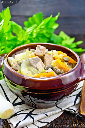 Image of Soup Eintopf in clay bowl on wooden board