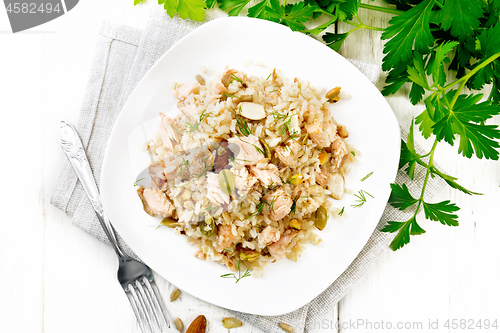 Image of Salad of salmon and rice in plate on board top