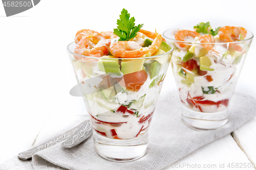 Image of Salad with shrimp and avocado in two glasses on table