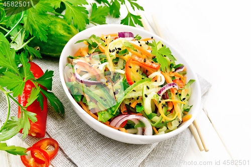 Image of Salad of cucumber in bowl on wooden board