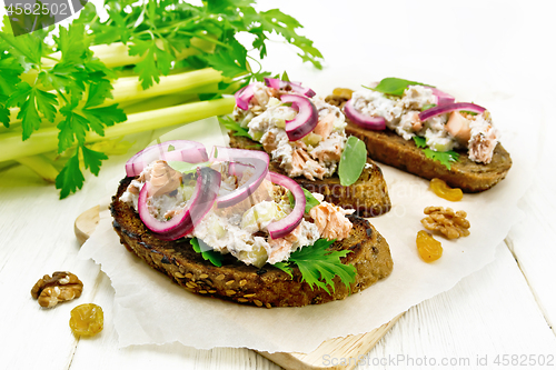 Image of Bruschetta with fish and curd on light wooden board