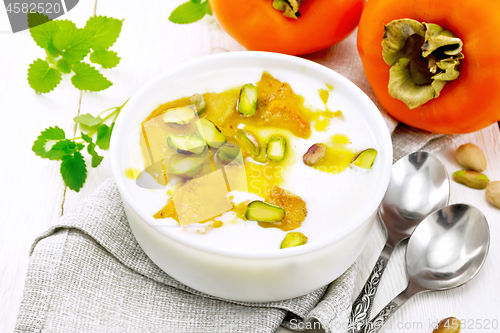Image of Dessert of yogurt and persimmon in bowl on light board