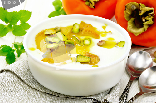 Image of Dessert of yogurt and persimmon in bowl on wooden board