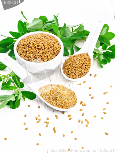 Image of Fenugreek in two spoons and bowl with leaves on white board