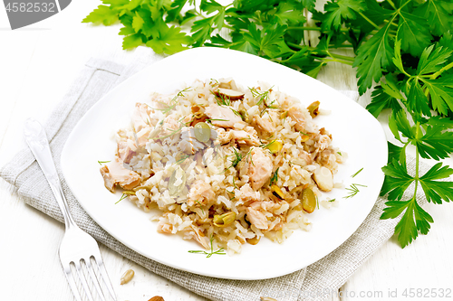 Image of Salad of salmon and rice in plate on wooden board