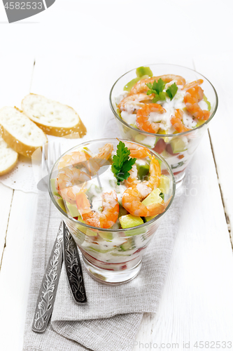 Image of Salad with shrimp and avocado in two glasses on board