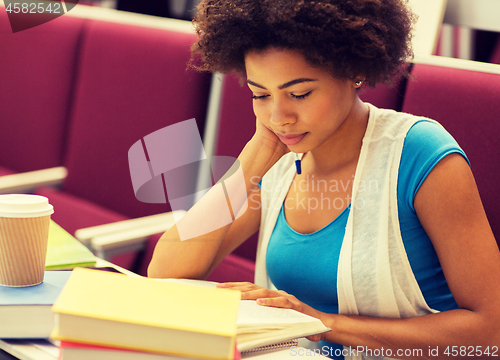 Image of student girl with books and coffee on lecture