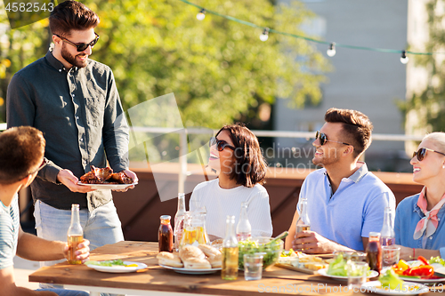 Image of friends at bbq party on rooftop in summer