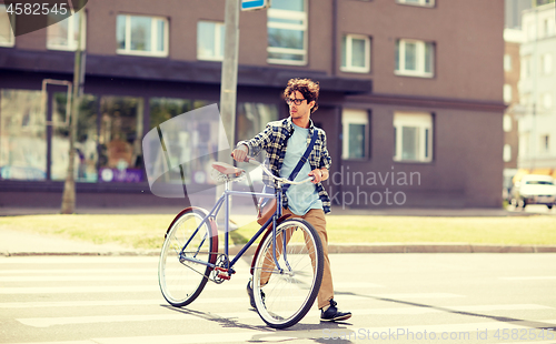 Image of young man with fixed gear bicycle on crosswalk