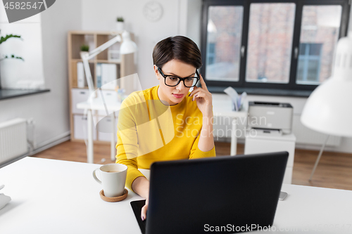 Image of businesswoman with laptop and coffee at office