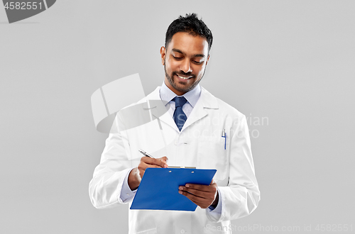 Image of smiling indian doctor or scientist with clipboard