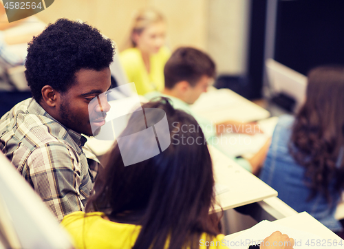 Image of group of students talking in lecture hall