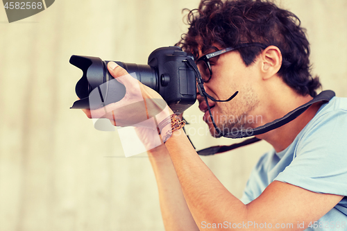 Image of close up of photographer with camera shooting