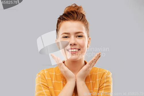 Image of smiling red haired teenage girl in checkered shirt
