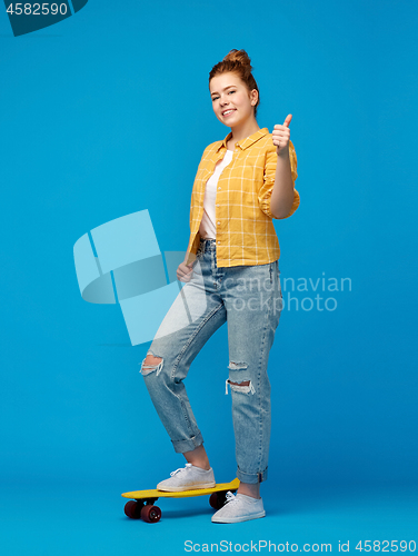 Image of teenage girl with skateboard showing thumbs up