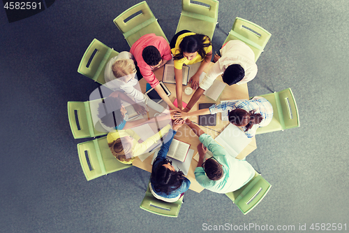 Image of group of international students with hands on top