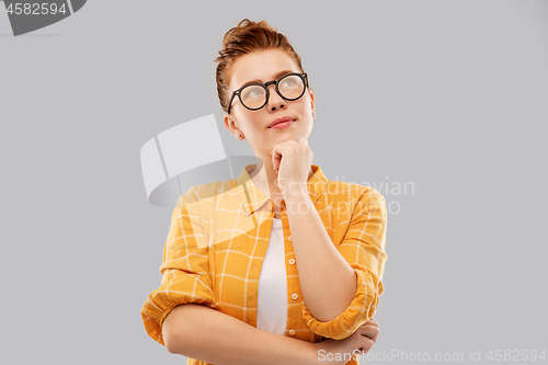 Image of thinking redhead teenage student girl in glasses