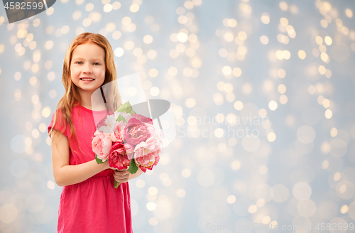 Image of happy red haired girl with flowers over lights