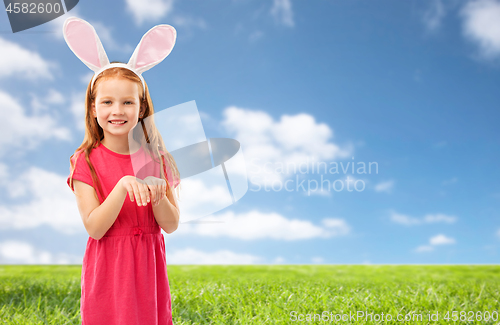 Image of happy red haired girl wearing easter bunny ears