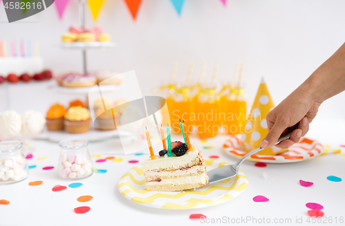 Image of hand putting piece of birthday cake on plate