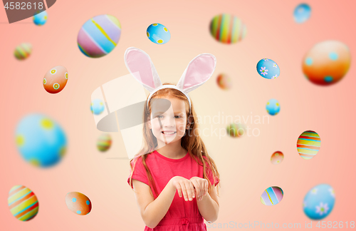 Image of happy red haired girl wearing easter bunny ears