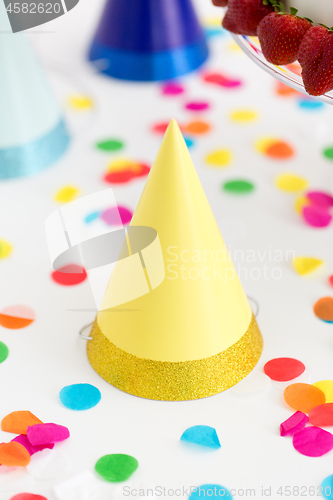 Image of yellow birthday party cap and confetti