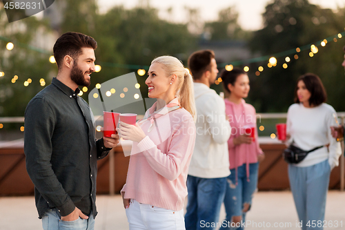 Image of friends with drinks in party cups at rooftop