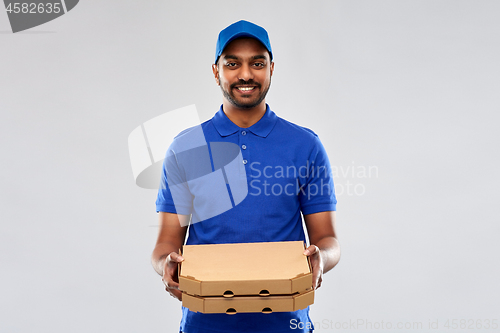 Image of happy indian delivery man with pizza boxes in blue