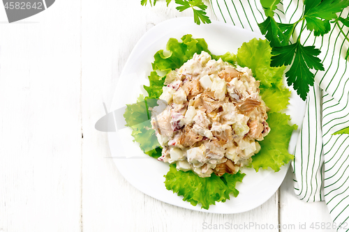 Image of Salad of salmon and cucumber in plate on board top