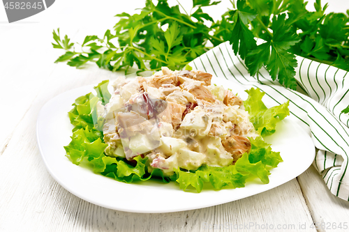 Image of Salad of salmon and cucumber in plate on light board