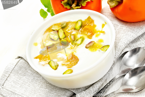 Image of Dessert of yogurt and persimmon in bowl on board