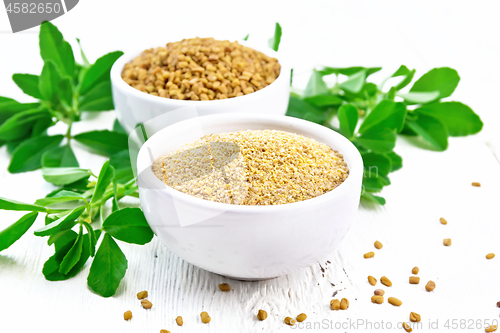 Image of Fenugreek in two bowls with leaves on wooden board