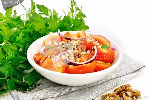 Image of Salad with tomato and walnut in plate on board