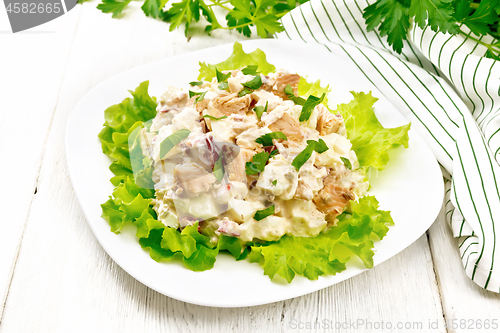 Image of Salad of salmon and cucumber in plate on wooden board