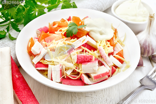 Image of Salad of surimi and tomatoes on light board