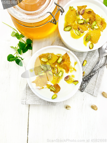 Image of Dessert of yogurt and persimmon two bowls on light board top