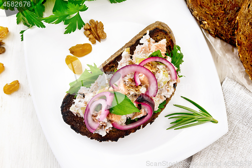 Image of Bruschetta with fish and curd in plate on board top