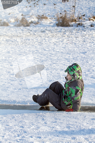 Image of Boy Sliding on Ice Rink