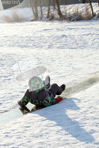 Image of Boy Sliding on Ice Rink
