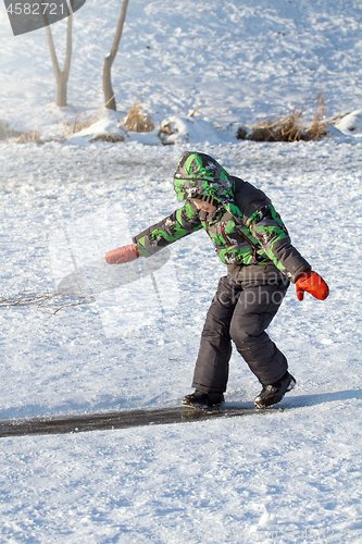 Image of Boy Sliding on Ice Rink