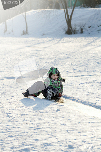 Image of Boy Sliding on Ice Rink