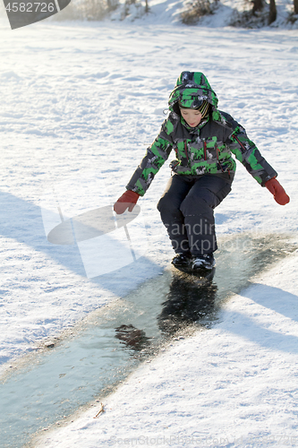 Image of Boy Sliding on Ice Rink