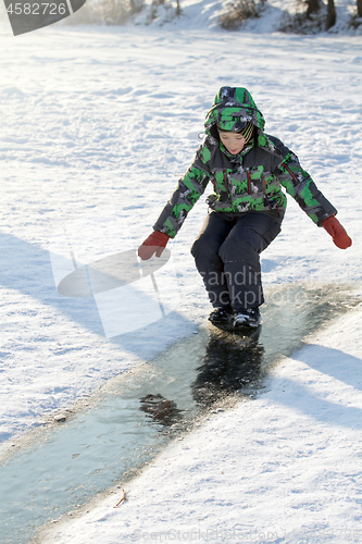 Image of Boy Sliding on Ice Rink